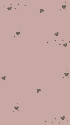 a pink wall with hearts on it and some black dots in the middle that are falling off