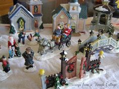 a table topped with lots of figurines on top of a white cloth covered table