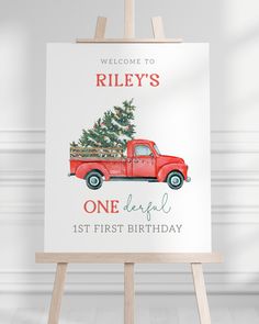 a red truck with a christmas tree on the back sits in front of a sign that says, riley's one beautiful 1st first birthday