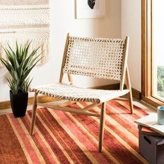 a living room with a chair, coffee table and potted plant