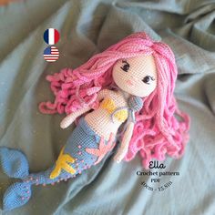 a crocheted mermaid doll laying on top of a bed