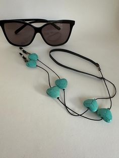 ★ Bold oversized turquoise hearts on a black cord ★ Black leather neck strap  ★ Black or white grips - Free extra grips  ★ Approximate length - 28 inches (70cm) Please double-check your delivery address so your order will not be returned to us. We cannot absorb the cost of resending. Thank you Handmade Adjustable Turquoise Glasses Chains, Adjustable Black Glasses Chains Fashion Accessory, Adjustable Black Glasses Chains For Fashion, Eyewear Chain, Eyeglass Necklace, Glasses Chains, Glasses Strap, Turquoise Heart, Eyeglass Chain