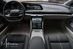 the interior of a modern car with black leather seats and dashboard controls, including an electronic display