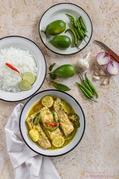 three bowls filled with food on top of a wooden table next to rice and green beans