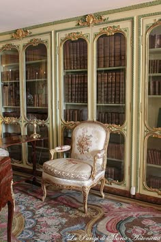 an antique chair sits in front of a bookcase