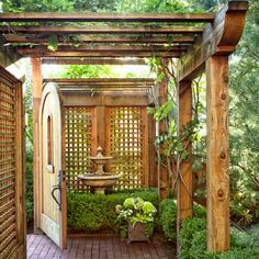 an outdoor garden with a fountain and wooden arbor