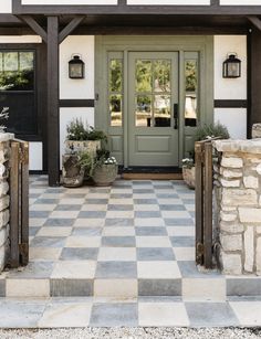 the front entrance to a house with potted plants