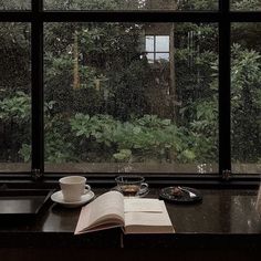 an open book sitting on top of a table next to a window