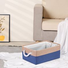 a blue and tan box sitting on top of a white rug next to a couch