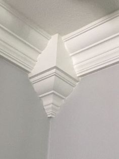 the corner of a room with white molding on the wall and ceiling above it