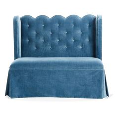 an upholstered blue velvet sofa with scalloped edges