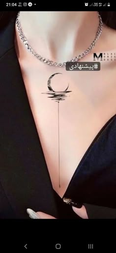 a woman wearing a black shirt with a crescent tattoo on her chest and the word moon written in arabic