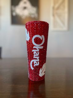 a red cup sitting on top of a wooden table