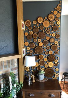 a wooden wall hanging on the side of a room next to a table with a lamp