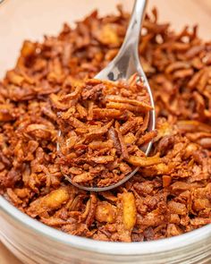 a bowl full of fried food with a spoon in it