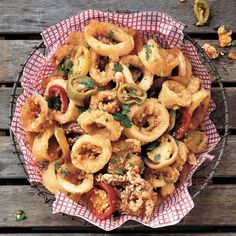 a bowl filled with fried food on top of a wooden table