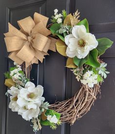 a wreath with white flowers and green leaves