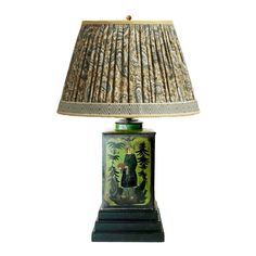 a lamp that is sitting on top of a wooden base with a green and yellow shade