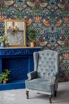 a blue chair sitting in front of a fire place next to a wallpapered fireplace