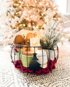 a basket filled with candles next to a christmas tree