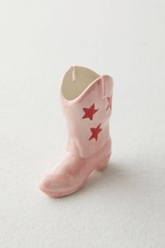 a pink boot with red stars on it sitting on top of a white tablecloth