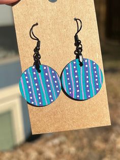 Bold patterned earrings. These are sure to make a statement, but just a little more subtle since they're smaller than our larger earrings. Purple and teal stripes with white dots, with a similar but different pattern on the back.  1 inch round, 1 inch drop Hand drawn and painted, each earring is slightly unique and made with care. Made from lightweight wood for all day comfort! Manufacturer claims on earring hooks are that they are stainless steel and hypoallergenic. All earrings are sprayed with a sealer to help protect the art. Hand Painted Artsy Earrings For Everyday, Multicolor Drop Earrings For Everyday, Artsy Hand Painted Earrings For Everyday, Artsy Hand Painted Everyday Earrings, Everyday Hand Painted Artsy Earrings, Hand Painted Bohemian Earrings For Everyday, Everyday Multicolor Circular Earrings, Everyday Multicolor Circle Earrings, Everyday Blue Circular Earrings