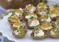 small appetizers on a white platter with green garnish and sprinkles