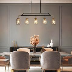 an elegant dining room with gray walls and gold accents, along with beige velvet chairs