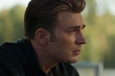 a close up of a person wearing a black shirt and looking off into the distance