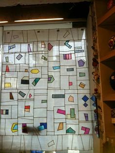 the window is decorated with colorful squares and shapes on it's glass coverings