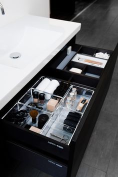 an open drawer in the middle of a bathroom sink