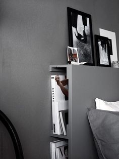 a bed room with a neatly made bed and some pictures on the wall above it