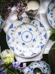 a table topped with plates covered in blue and white flowers