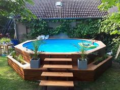 an above ground swimming pool with steps leading up to it and plants growing on the deck