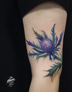 a woman's leg with a blue flower tattoo on her left thigh and the bottom part of her arm