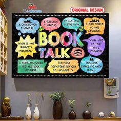 a sign that says book talk is hanging on the wall next to some vases