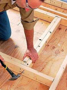 a man is working on framing with a pair of hammers in his right hand