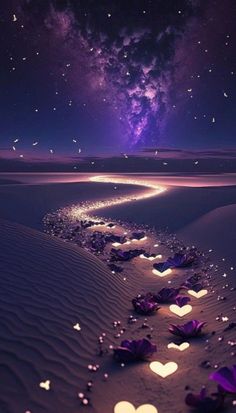 hearts in the sand at night time with stars and lights on it's side