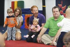 a group of people that are sitting on the ground with a baby in front of them