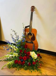 a guitar and flowers sit on the floor