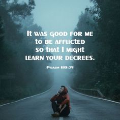 a person kneeling down on the side of a road with a bible verse above it