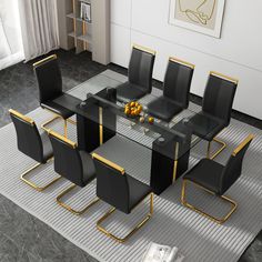 a modern dining table with black chairs and gold trimmings on the legs is shown