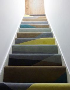 the stairs are painted in different colors and patterns, with an open door leading to another room