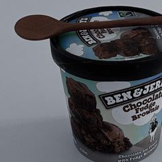 an ice cream container with chocolate brownie inside and a wooden spoon sticking out of it