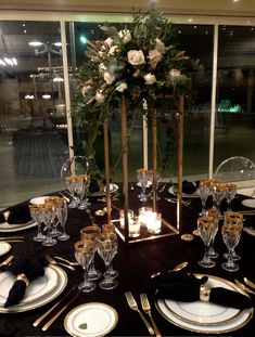 the table is set with black and gold place settings