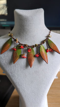 a necklace with leaves and berries on it