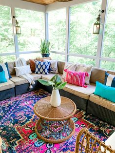 a living room filled with lots of furniture and pillows on top of a colorful rug