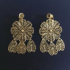 Vintage Filigree Earrings. Gold Toned metal. These are NOS (new old stock) and have never been worn.   For pierced ears.  Please visit my shop for more unique jewelry! I combine shipping. First Class packages will be shipped bubble wrapped inside of a padded envelope. Priority Mail packages will be shipped bubble wrapped in a box. Any displays not included in sale unless otherwise noted. Coin in photo for size reference. Feel free to reach out with any questions, thank you for visiting my shop! Gold Clip-on Drop Flower Earrings, Gold Filigree Drop Flower Earrings, Antique Gold Metal Chandelier Earrings, Vintage Gold Flower Earrings For Gift, Gold Clip-on Drop Earrings With Intricate Design, Antique Gold Dangle Clip-on Earrings, Vintage Gold Earrings For Pierced Ears, Antique Gold Drop Clip-on Earrings, Vintage Metal Flower Earrings For Pierced Ears