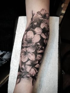 a woman's arm with black and white flowers on it