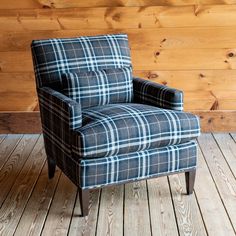 a chair sitting on top of a wooden floor next to a wood paneled wall